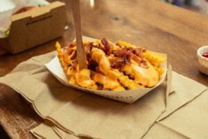 Indulge in crispy crinkle-cut fries topped with gooey cheese sauce and savory bacon.